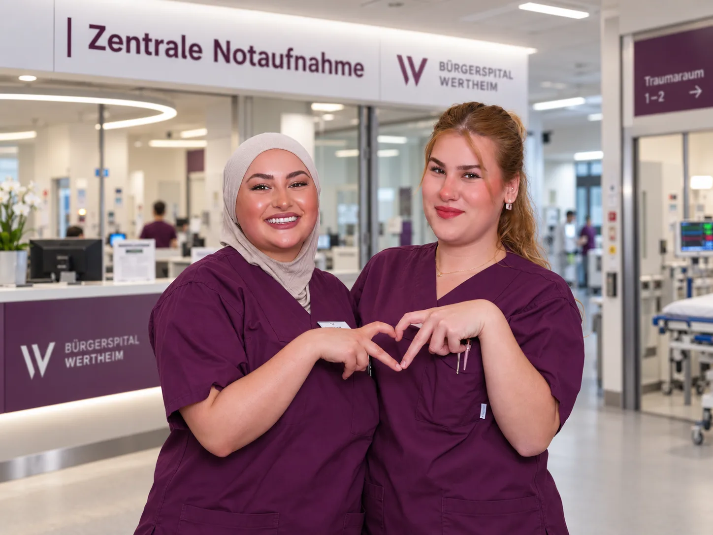 Zwei Pflegekräfte des Bürgerspitals Wertheim formen vor der Zentralen Notaufnahme mit den Händen ein Herz